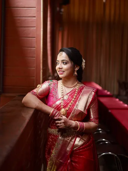 An elegant portrait of the bride. The lighting highlights the smooth finish of her makeup and the intricate details of her jewellery.