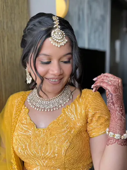A close-up of the Haldi look, showing the beautiful henna and the soft, glowing makeup.