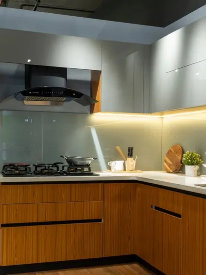 Another view of the wood and gray kitchen, highlighting the open wicker basket storage for vegetables and the sleek chimney hood.