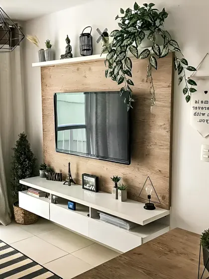 A compact and stylish TV unit solution for smaller living rooms. The light wood back panel adds warmth, while the floating white console provides storage without taking up floor space, keeping the area feeling open and airy.