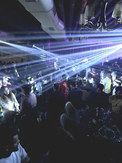 A sea of people under the professional lighting rig. I work with venues to create a truly immersive experience.