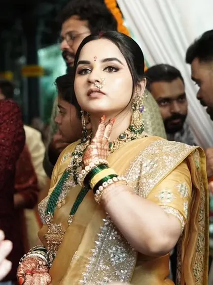 An elegant look for a wedding guest. The golden saree is paired with a subtle smokey eye and a classic updo.