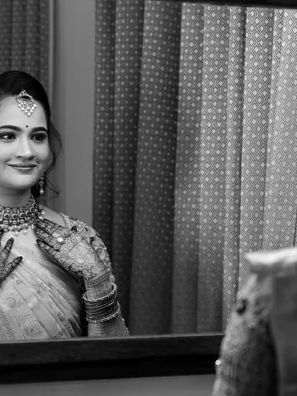 A timeless black and white shot of Vibha admiring her reflection. This captures the quiet, happy moments before the main event.