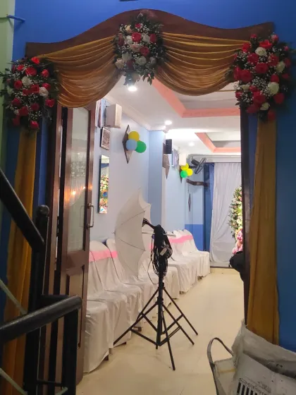 The entrance to a home decorated for a baby shower, with floral arrangements and drapery.