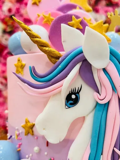 A close-up view of the intricate fondant work on one of my unicorn cakes. The colorful mane and golden horn are crafted by hand to create a stunning effect.