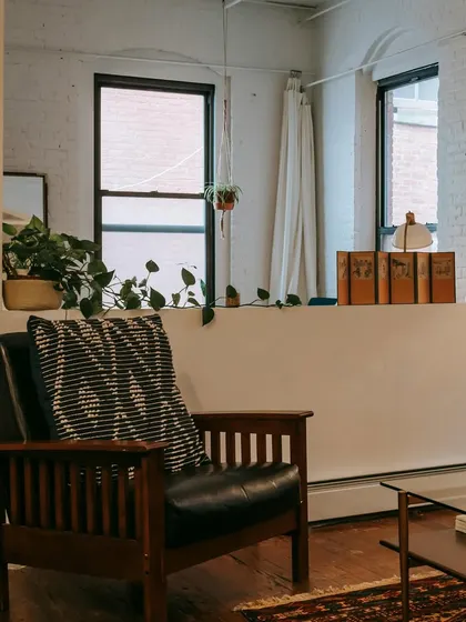 This living room corner features a classic leather armchair and exposed brick, demonstrating our versatility in creating rustic and industrial-inspired spaces.