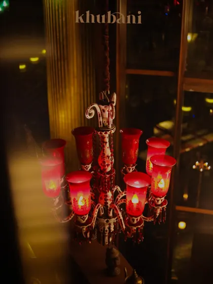 Step into enchantment. This beautiful red glass chandelier casts a warm, inviting glow, making every night feel like a royal affair.