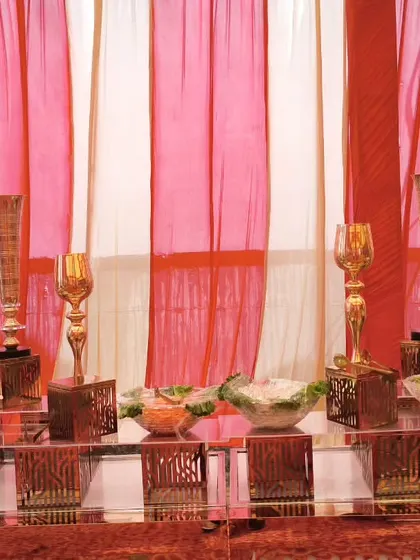 A detailed shot of our salad bar with decorative golden goblets and bowls. The contrast between the red and white drapes and the ornate counter creates a visually appealing food station.