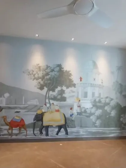 A full view of a heritage-style mural installed in a large room. The artwork, featuring elephants, camels, and classic architecture, transforms the space with its epic and story-rich visuals.