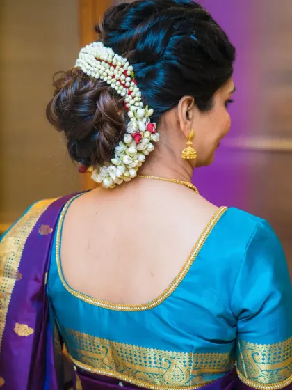 A classic and elegant messy bun adorned with a beautiful gajra. This hairstyle is perfect for a traditional look, like for this naming ceremony.