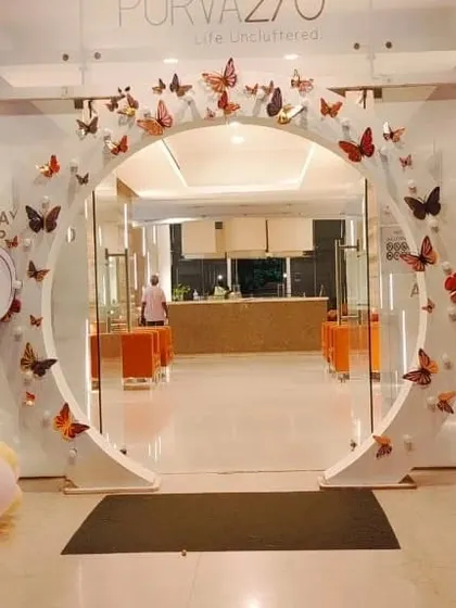 An elegant entrance arch designed for a Puravankara corporate event. The clean white circular arch is decorated with butterfly cutouts, creating a sophisticated and welcoming entrance for guests.
