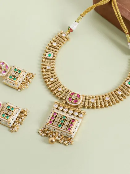 A flatlay of a traditional Meenakari necklace set. The light green background complements the colors in the jewelry, creating a soft and elegant presentation.