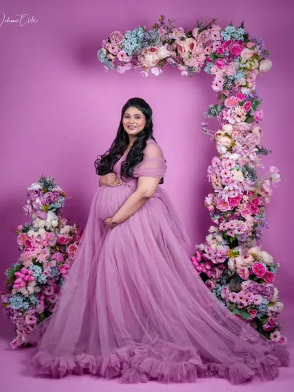 A stunning maternity shoot in a lavender gown. The soft, ethereal makeup complements the floral theme perfectly.