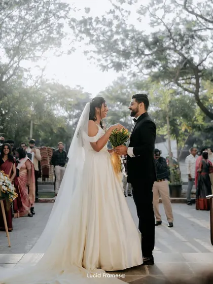A beautiful wide shot of the couple's first look, surrounded by guests and the lovely outdoor setting.