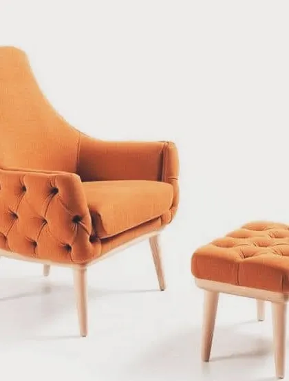 A comfortable and stylish accent chair with tufted upholstery in a vibrant orange fabric. It comes with a matching ottoman, perfect for creating a cozy reading nook.