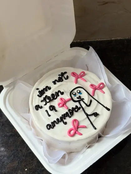 Marking the big 2-0 with humor! This cute bento cake features a crying stick figure and the text "I'm not a teen anymore," surrounded by pretty pink bows.