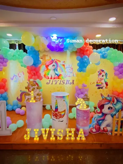 Another angle of the unicorn birthday setup, showing the full stage with the balloon arch, themed cake stands, and marquee letters.