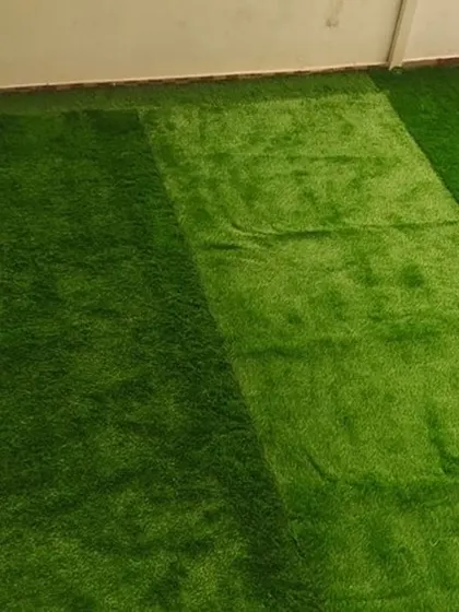 A completed artificial grass installation on a balcony. The result is a vibrant, green, and soft surface that requires no watering or mowing, instantly making the space more inviting.