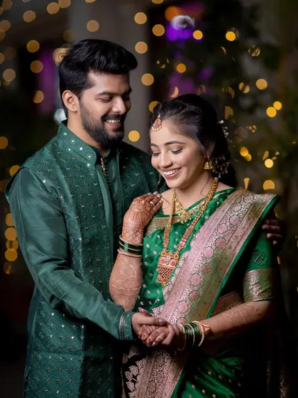 A joyful couple portrait, capturing their smiles and the beautiful details of their green engagement outfits.