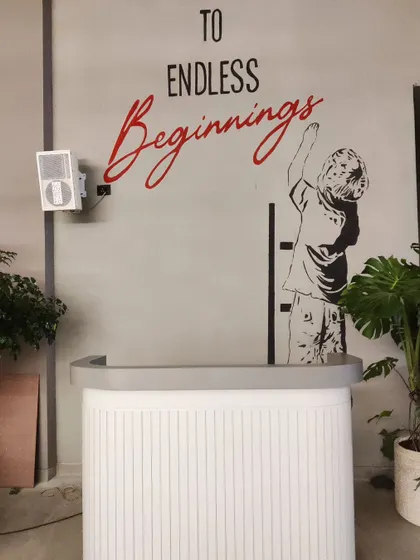 'To Endless Beginnings'. We painted this inspirational quote mural for a design store's reception area, combining typography with a Banksy style illustration.