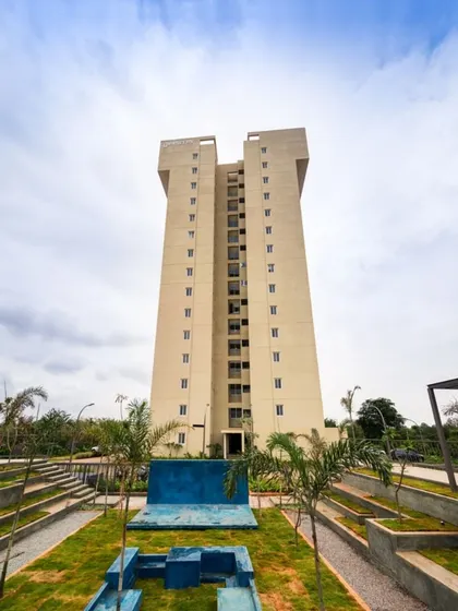 The apartment tower seen from its landscaped grounds. The design includes stepped gardens and outdoor seating areas, creating a green buffer and community space at the base of the high-rise structure.