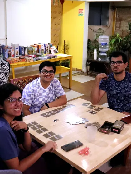 Three friends getting ready for a game of 'Omerta'. The shelf of board games in the background shows just a fraction of what I have to offer.