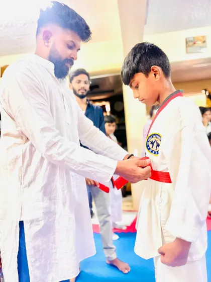 Tying the red belt for a deserving student.