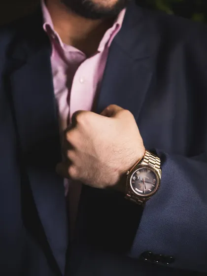 A detail shot of the groom's watch and suit cuff.