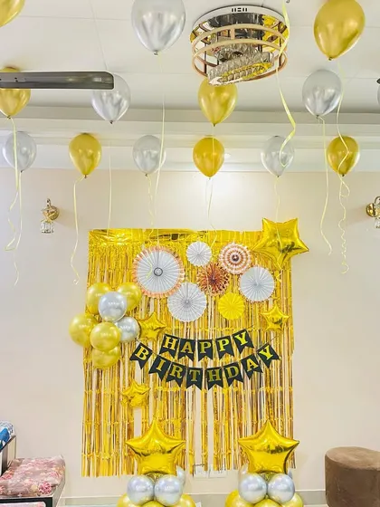 The same gold and silver birthday setup shown in brighter lighting.