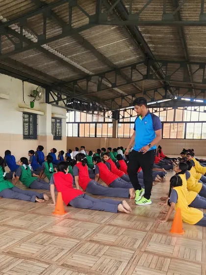 A coach guides students through a yoga session, ensuring they maintain proper form. Expert instruction is key to maximizing the benefits and preventing injury.