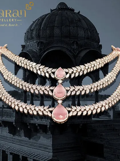 A full product shot of the three-layered pink stone and zircon necklace, showcasing its beautiful design against a dramatic background. This piece is a true work of art.