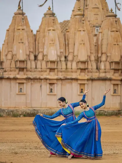 A graceful pose showing the elegant lines of our arms and bodies. The synchronicity between us is a result of years of dedicated practice and a deep sisterly bond.