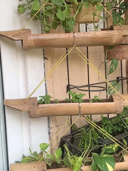 To maximize space, we can use creative vertical solutions like these tiered bamboo planters, perfect for growing smaller plants and vines.