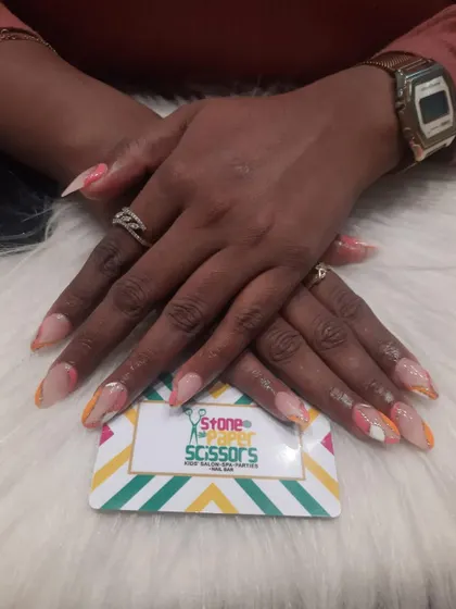 This design features colorful swirls on the tips of the nails, creating a subtle pop of color against the natural base. It's a fun, abstract look for medium-length nails.