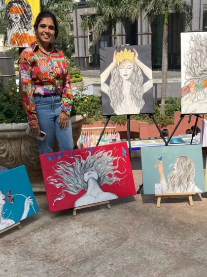 An artist with her collection of portraits celebrating women, displayed at our 'Sublime Fiesta' event.