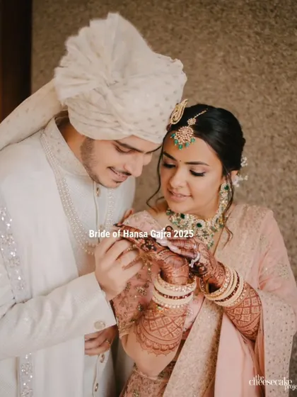 A sweet moment where the groom admires the bride's mehendi. This candid shot captures a small, intimate part of their big day, full of love and appreciation.