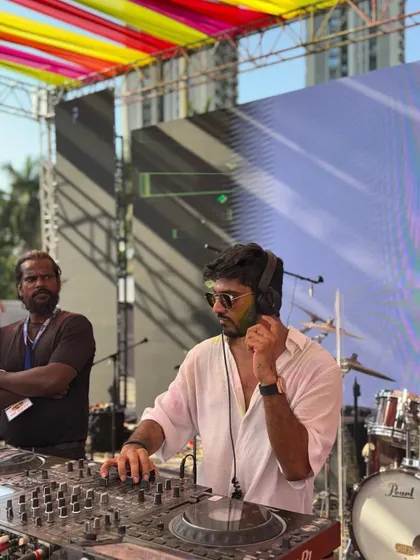 Adjusting my headphones, getting ready for the next transition. A behind-the-scenes look at a live DJ performance during a massive outdoor event.