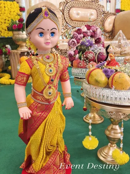 Another example of a beautifully dressed doll for a seer plate arrangement, placed among trays of fresh fruits and flowers.