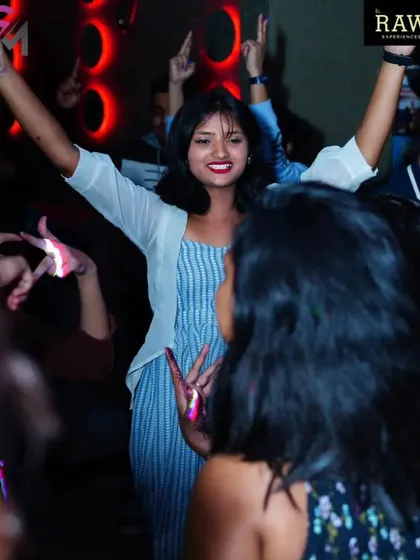 A guest with her hands up, feeling the freedom of the dance floor. It's all about creating a space for people to express themselves.