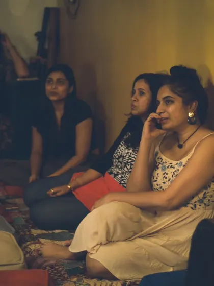 An audience member enjoying the show. The relaxed, floor-seating arrangement makes everyone feel like they're part of a big, music-loving family.