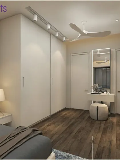 This bedroom in 'Konark Splendor' showcases a clean, modern design with handle-less sliding wardrobes and a simple, elegant dressing table setup.