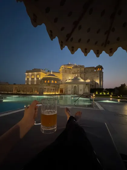 Capturing the serene moments of a luxury hotel stay. This shot from the Fairmont Jaipur shows the stunning poolside ambiance at dusk, selling an experience of relaxation and opulence that goes beyond just a room.