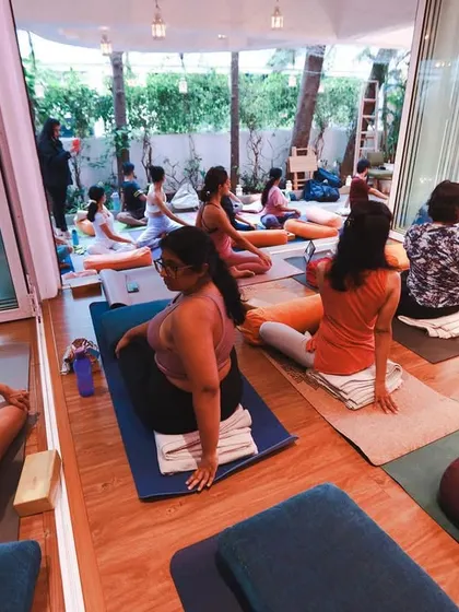 A wide view of a class, showing how our glass doors open up to connect the indoor studio with the outdoor patio, creating one large, unified practice space.