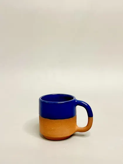 A single cobalt blue and terracotta mug. The contrast between the raw clay and the vibrant glaze is a signature part of this design, bringing beauty to your everyday routine.