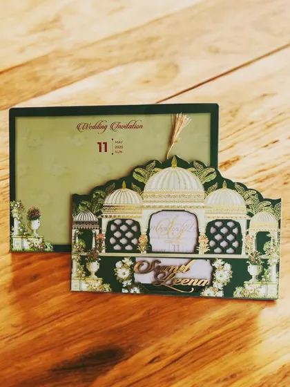 A palace-themed laser-cut invitation in deep green and gold, offering a regal and architectural design for a grand wedding.