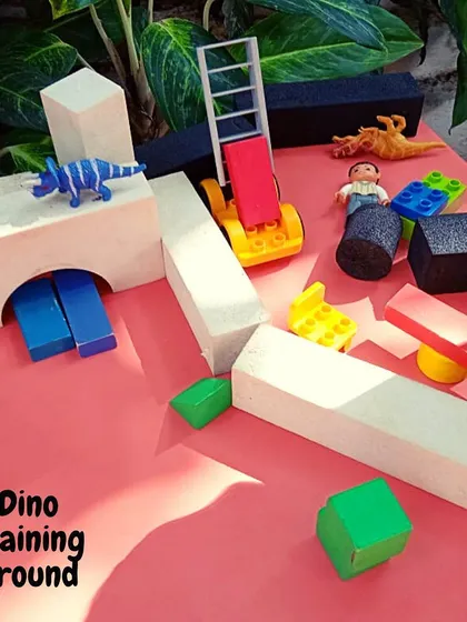 A 'Dino Training Ground' set up with blocks and toys invites children to engage in pretend play. These open-ended setups allow them to create their own narratives and explore the characteristics of their favorite dinosaurs.