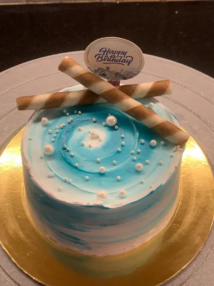 A small and simple blue and white swirled bento cake. Topped with chocolate wafer sticks, it's a perfect little treat.
