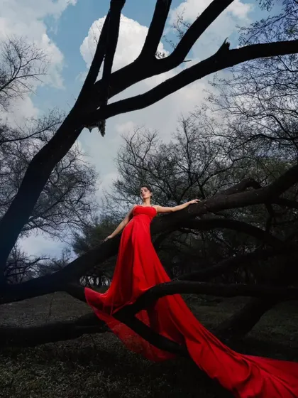 For the bride who is bold and fearless. This vibrant red trail gown looks absolutely stunning against the dramatic, moody backdrop, creating a powerful and artistic pre-wedding photograph.