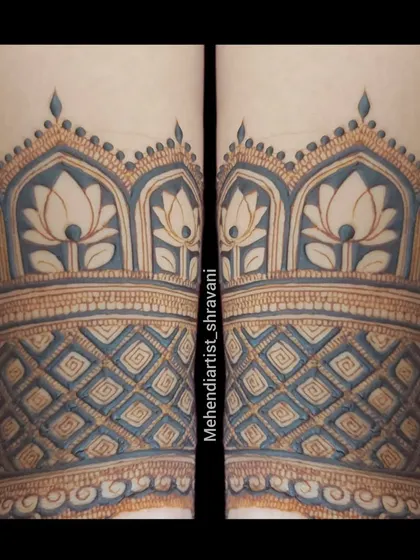 A close-up of a forearm band with a beautiful blue-tinted effect. This shows how traditional lotus and dome patterns can be given a unique visual twist.