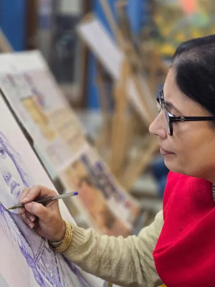 A profile shot of a student focused on her portrait drawing, demonstrating the careful precision taught in our classes.